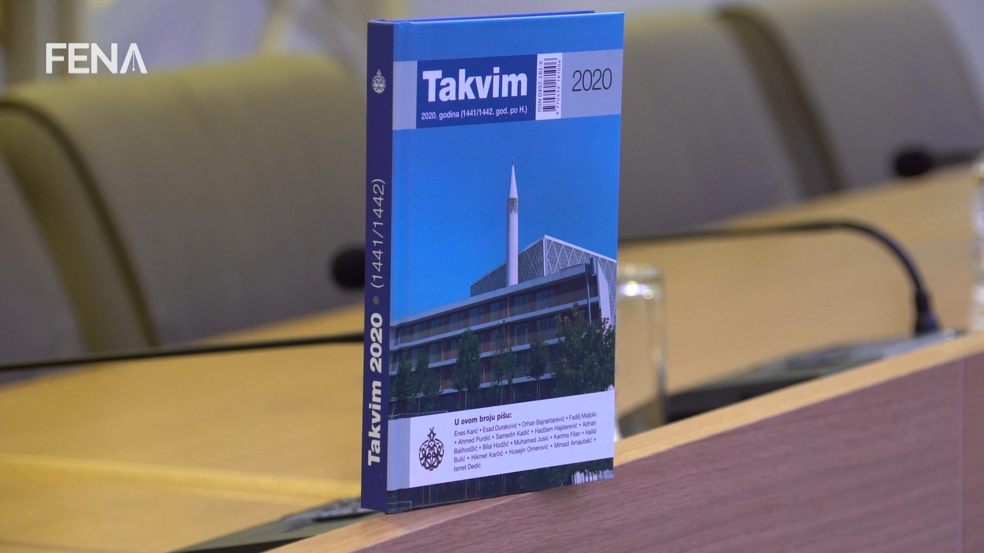 Kaur'an na polici, sedžda u ćošku, levha na zidu i Takvim u obiteljskoj biblioteci
