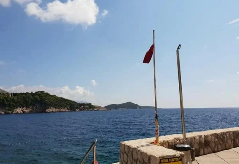 Onečišćeno more na plaži u Dubrovniku, istaknuta crvena zastava